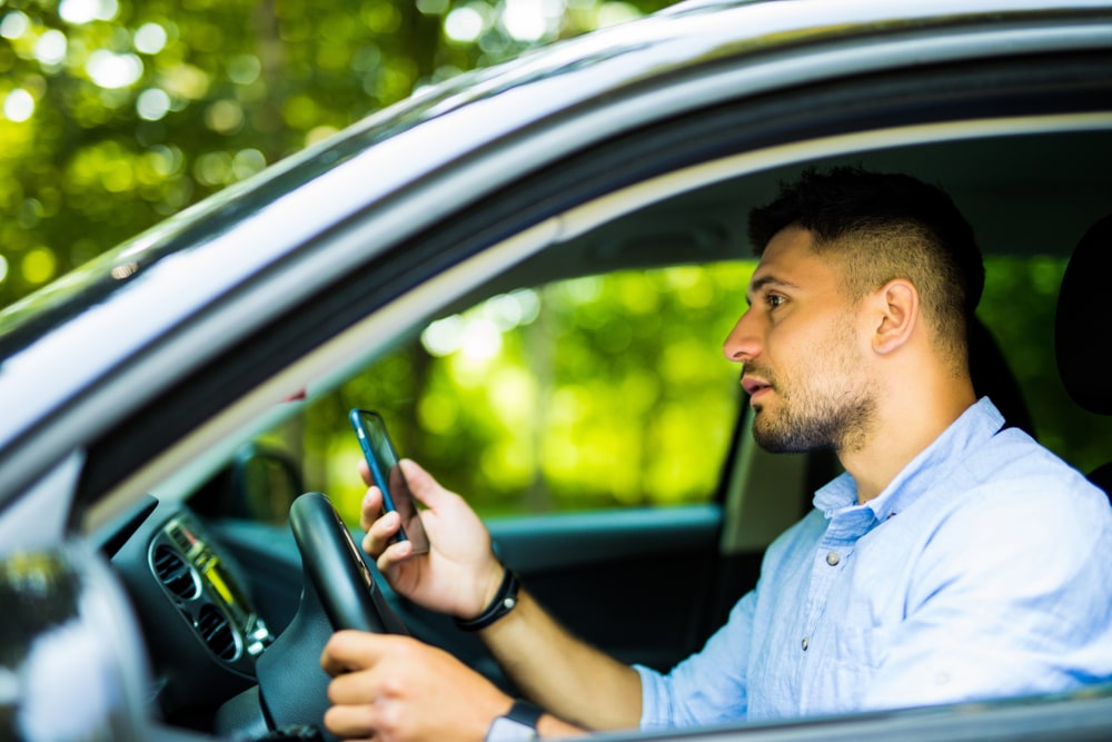 Person Holding Phone While Driving